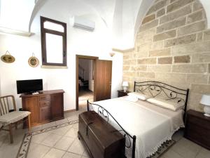 a bedroom with a bed and a stone wall at Casa Naida in Nardò
