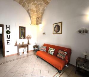 a living room with an orange couch in a room at Casa Naida in Nardò +48 photos