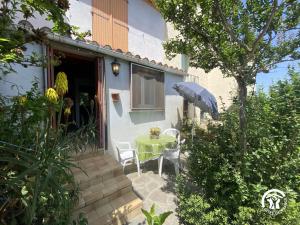 een terras met een tafel, stoelen en een parasol bij Mas garrigole in Eus +6 foto's