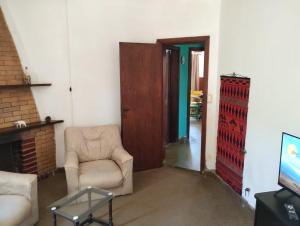 een woonkamer met een stoel en een televisie bij Casa de playa. Quequen in Quequén