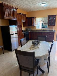 una cucina con tavolo con sedie e frigorifero di Glenmuir Villa a May Pen