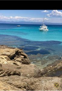 a boat in the water near the shore at Domek na Lazurowym Wybrzeżu in Gassin