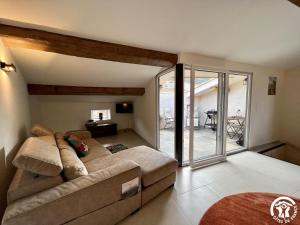 een woonkamer met een bank en een glazen schuifdeur bij Helena in Quintillan