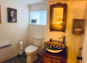 ein Badezimmer mit Toilette, Waschbecken und Spiegel in der Unterkunft Chalet -Havre au bord de l'eau in Chertsey + 47 Fotos