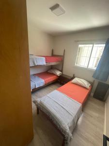 ein Zimmer mit drei Etagenbetten und einem Fenster in der Unterkunft Mansilla playa in Mar del Plata