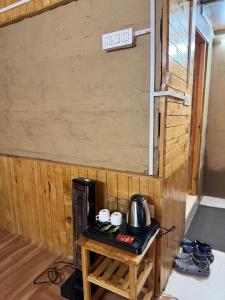 a small table with a tea kettle on it at Mountain Nest Stay in Jibhi