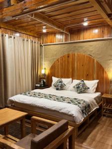 a bedroom with a large bed with a wooden headboard at Mountain Nest Stay in Jibhi