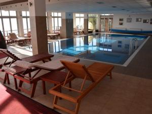 a large swimming pool with chairs and tables in a building at Sky Cabin Apartments - FREE GARAGE in Kopaonik