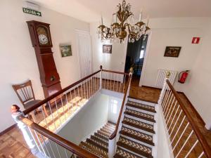 eine Treppe in einem Haus mit einer Uhr an der Wand in der Unterkunft Casa Rural Masión de Egüés in Elcano