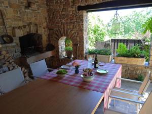 een houten tafel in een kamer met een bakstenen muur bij L'oree de la gresigne in Cordes-sur-Ciel +31 foto's