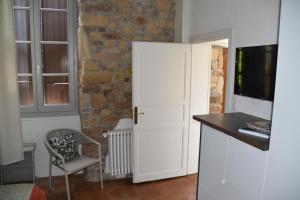 een keuken met een witte deur en een stoel bij L'oree de la gresigne in Cordes-sur-Ciel