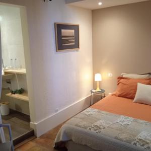 een slaapkamer met een bed en een schilderij aan de muur bij L'oree de la gresigne in Cordes-sur-Ciel