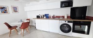 een keuken met een wasmachine en een wastafel bij Duplex Saint-Martin in Josselin +5 foto's