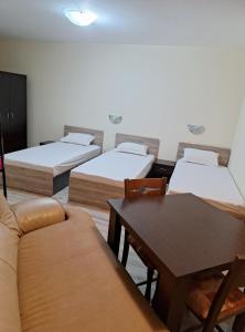 a room with three beds and a couch and a table at LaRaMi Studio in Sveti Vlas