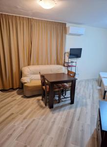 a living room with a couch and a table at LaRaMi Studio in Sveti Vlas