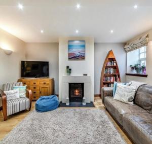 un soggiorno con divano e camino di Puffin Cottage, Bamburgh a Bamburgh