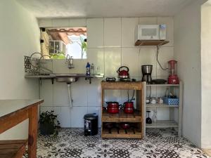 a kitchen with a sink and a shelf with pots at Suites casa do indio jungle, a melhor vista da floresta in Abraão +60 photos