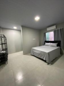 een slaapkamer met een bed en een stoel erin bij AP Quatro Estações in Miguel Pereira