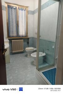 a bathroom with a toilet and a glass shower door at AR lodges in Montecosaro