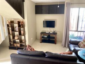 een woonkamer met een bank en een flatscreen-tv bij Golden House in Tijuana