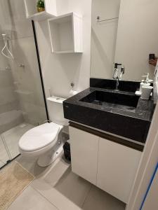 een witte badkamer met een toilet en een wastafel bij Studio Vila Eco Barra in Barra Grande +9 foto's