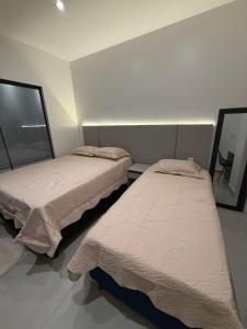 twee bedden in een kleine kamer met ermottermottermott bij Studio Vila Eco Barra in Barra Grande