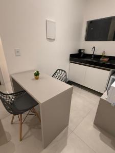 een keuken met een witte tafel en een wastafel bij Studio Vila Eco Barra in Barra Grande