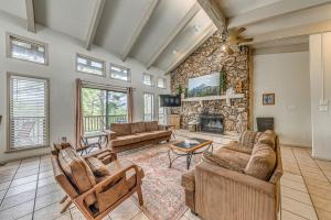 un soggiorno con divani e un muro in pietra di Ruidoso Home with Private Wet Bar and Pool Table a Ruidoso