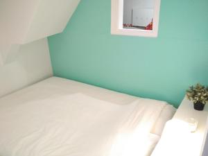 a bedroom with a white bed and a blue wall at Rosinha 82 Apartment in Lisbon