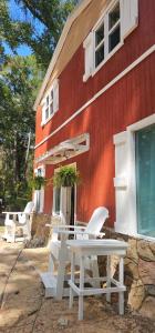 a table and chairs in front of a red building at Paradise Gardens Glamping in Westville