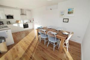 a kitchen and dining room with a wooden table and chairs at 3 Bed in Gower oc-hh2105 in Rhossili