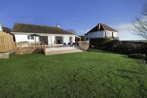 une maison blanche avec une terrasse couverte et une cour dans l'établissement 3 Bed in Gower oc-hh2105, à Rhossili