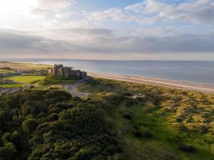 an aerial view of lichfield castle overlooking the beach at 3 Bed in Belford oc-79178 in Belford