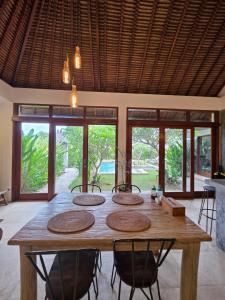 a dining room with a wooden table with chairs at Guava Garden in Gili Trawangan