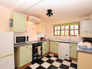 a kitchen with green cabinets and a checkered floor at 2 Bed in Godshill oc-ic072 in Godshill +5 photos