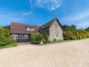 a large stone house with a gravel driveway at 2 Bed in Godshill oc-ic072 in Godshill