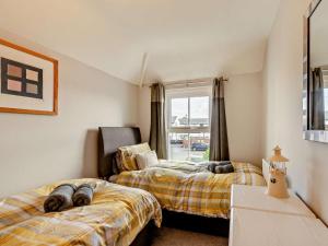 two beds in a room with a window at 2 Bed in Seahouses oc-cn082 in Seahouses