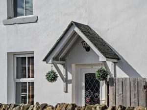 a white house with a door and a fence at 2 Bed in Seahouses oc-cn082 in Seahouses