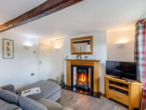 a living room with a fireplace and a tv at 2 Bed in Ambleside oc-89748 in Hawkshead
