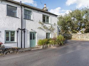 a white house with a blue door on a street at 2 Bed in Ambleside oc-89748 in Hawkshead