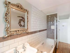 a bathroom with a tub and a sink and a mirror at 2 Bed in Ambleside oc-89748 in Hawkshead +7 photos