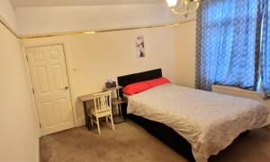 een slaapkamer met een bed, een tafel en een raam bij Premium Stay Experience in Bristol