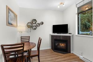 une salle à manger avec une table et une cheminée dans l'établissement Alpenglow Lodge Junior One Bedroom by MVA, à Whistler