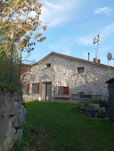 een stenen huis met een grasveld ervoor bij Casa Umberna in Asiago