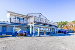 a bus parked in front of a blue building at Whispering Pines by Hotel O White stone VA in White Stone