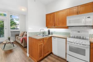 - une cuisine avec des appareils électroménagers blancs et un canapé dans l'établissement Alpenglow Lodge Junior One Bedroom by MVA, à Whistler