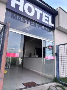 a hotel with a sign on the front of a building at Hotel Master Plaza Formiga in Formiga