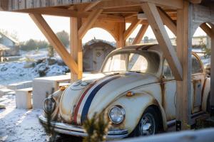 een oude auto geparkeerd onder een houten constructie bij Chalets Waldeck - Urlaub im Fränkischen Seenland und Altmühltal 