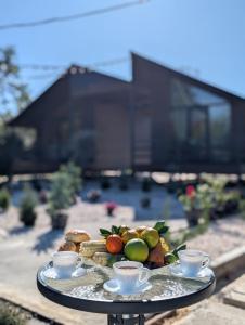 a tray of fruit and tea cups on a table at Our village in Khoni