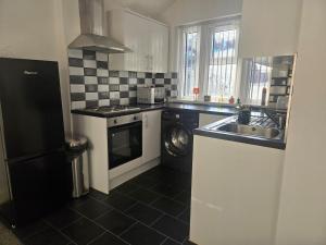 a kitchen with a sink and a stove and a dishwasher at 1 Bed City Centre Apartment in Derby